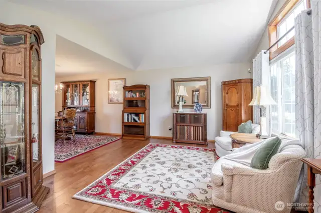 Formal living room with vaulted ceilings and natural light.