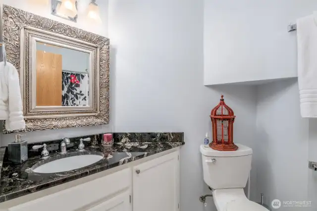 Secondary guest full bath with updated cabinets, countertops and tile floors.