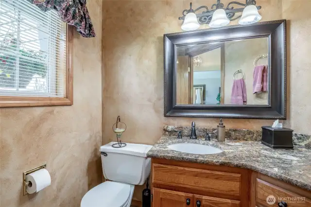 Gorgeous half bath on main floor with granite countertop and tile floor.