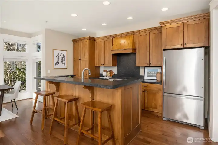 The kitchen is finished with stone tile countertops, stainless steel appliances, and beautiful cabinetry.