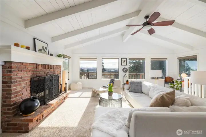 Walls of windows welcome in natural light and frame breathtaking scenery.    Note the stair rail leading down to the lower level.