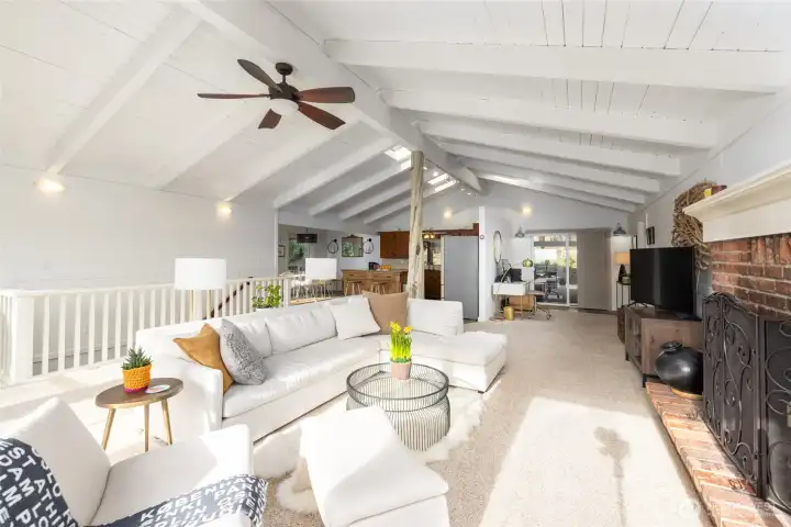 Gather around the cozy brick hearth for warmth and conversation or bask in natural light. This inviting space with a neutral palatte awaits your personal touch.