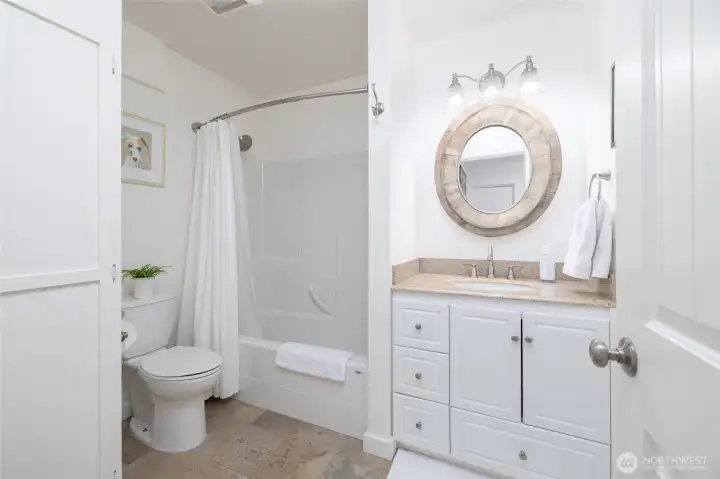 One of three bathrooms, the second lower-level full bath, situated off the dressing room, and third bedroom, includes a soaking tub.