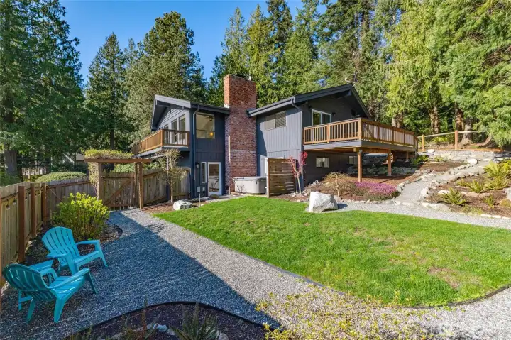 Large and lovely firs wrap this classic NW contemporary home set on a wide lot, lending privacy, and play space.