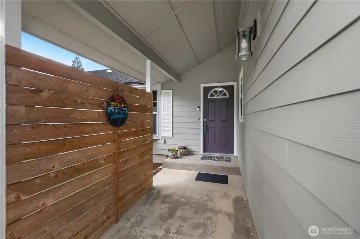 Entry way covered and privacy fence and shrub.