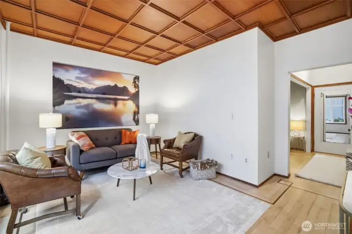 Inviting living space that captures the character of this turn-of-the-century co-op. The coffered wood ceiling adds warmth and architectural detail, while clean walls and updated finishes keep the room feeling fresh and livable. Generous proportions allow for multiple seating areas, creating a comfortable setting for both everyday living and hosting. A timeless blend of historic charm and modern simplicity in the heart of Capitol Hill.
