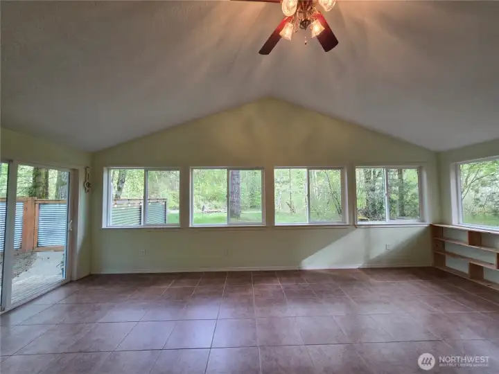 The sun room or rec room overlooks the river and also has the slider to head outside. It's valued ceilings and wall of windows allow for whatever you want to use this room for.