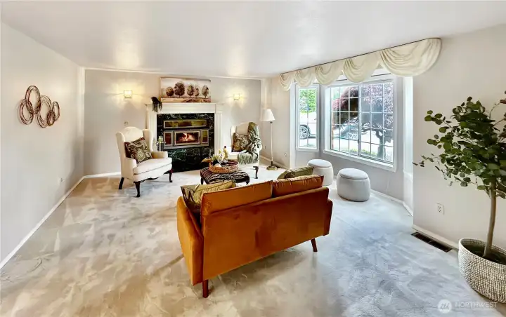 Beautiful living room with bay window and wood burning fireplace just off entry.