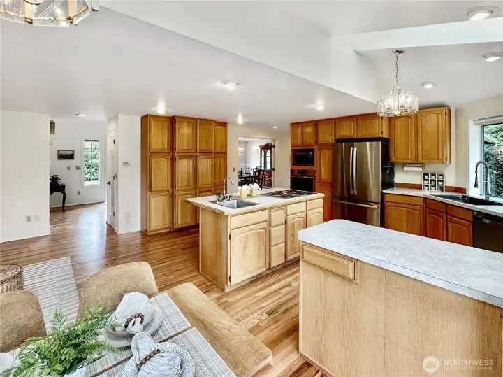 Looking from kitchen nook, wall of pantry cabinets, island, new dishwasher too.