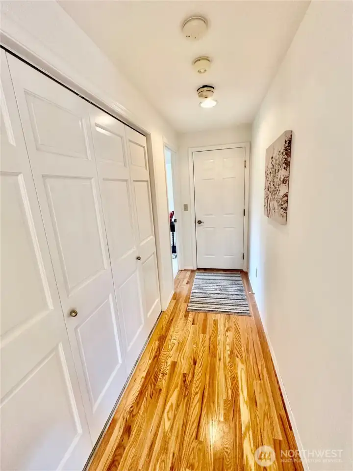 Hallway to main floor primary - wonderful storage throughout home.