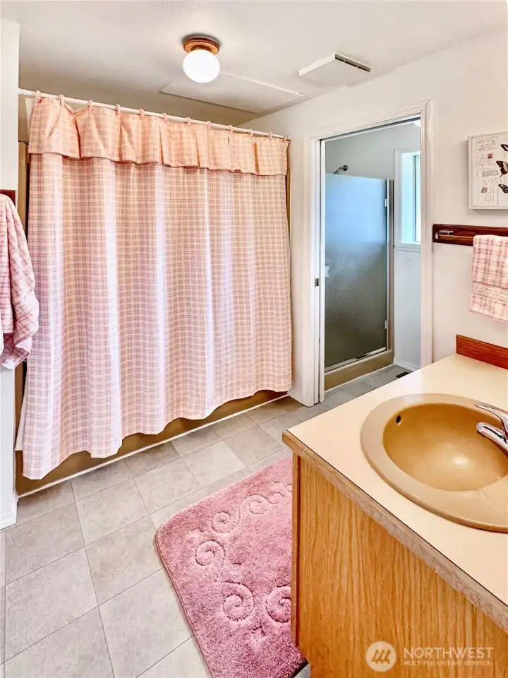 Main floor primary bath offers tub and separate toilet and shower room.