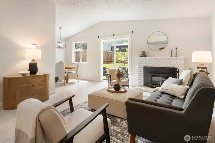 Brightness and a sense of levity come courtesy of the living room’s abundant natural light and vaulted ceilings. Sliders offer easy living room access to the fully fenced backyard and patio.