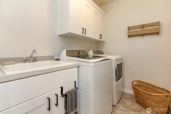 upstairs laundry room with sink and cabinets!