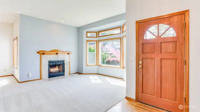 Entrance to the home opens to your formal living room boasting an abundance of natural light and wood burning fireplace.