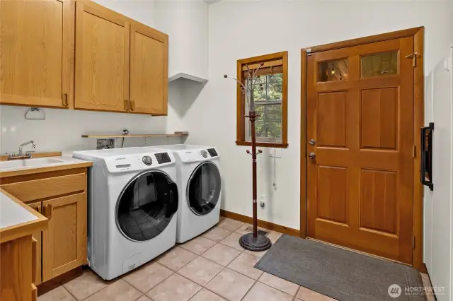 Mud room with washer, dryer., and utility sink.