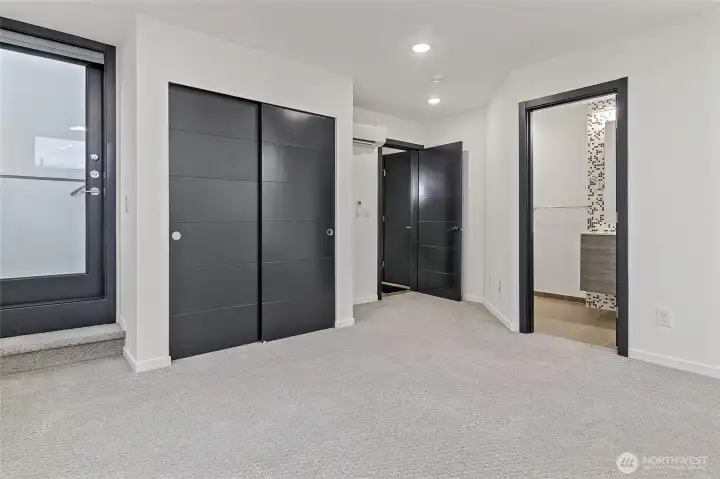 Primary bedroom located on 3rd floor with mini split for heating and cooling.  Easily fit a King bed in the 13'11" x 15'7" room.  Additional closet at top of stairs on third floor.  Door on left leads to rooftop deck.