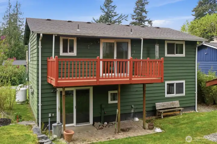 Back of home with large deck and lower level patio