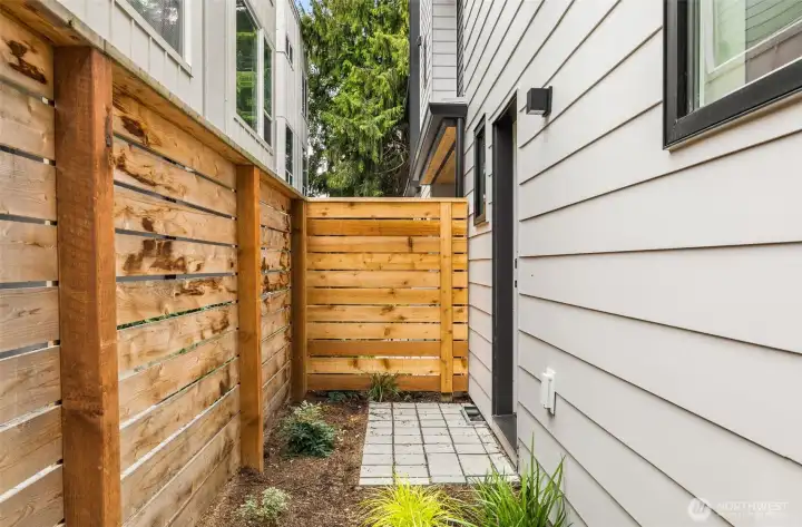 Cozy landscaping on the back & side of the home, perfect for pets!