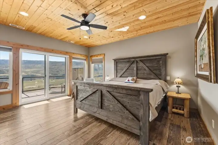 Large primary bedroom suite w/ pine ceilings, Milgard windows and double glass sliding doors leading onto the view deck overlooking the Columbia River and surrounding mountains.