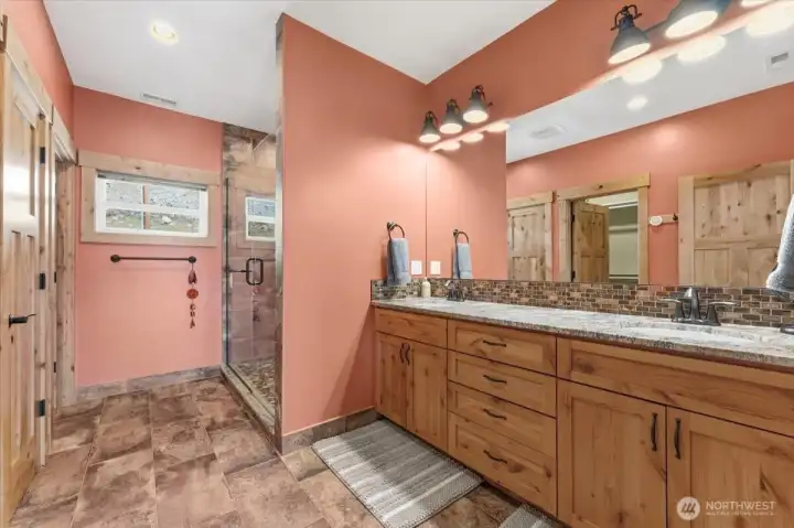 Large primary bathroom suite w/ walk-in closet, radiant heated ceramic tile floors, frameless glass and tile shower hickory cabinetry and granite countertops.