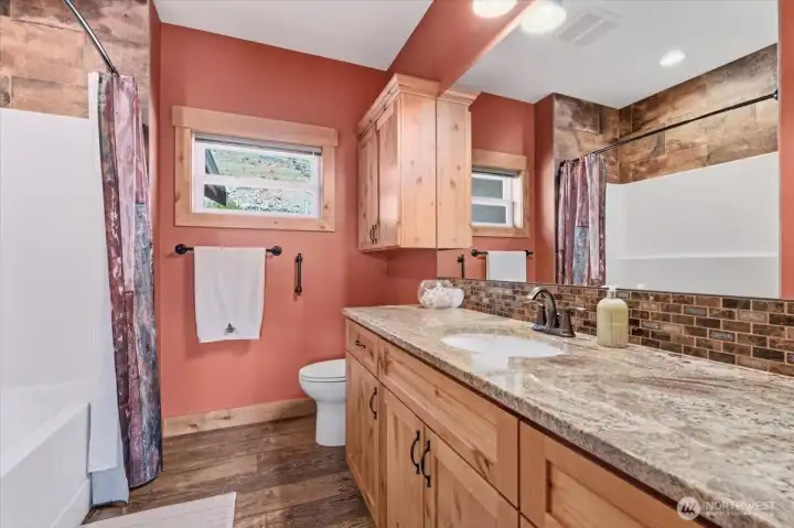 Main level guest bathroom 2 w/ hickory cabinetry and doors, oiled bronze hardware and granite countertops.
