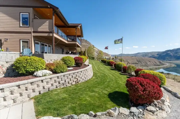 Fully-irrigated landscaping w/ grassy lawn area, terraced walls, orange rocket barbary, burning bush, flowering cherry trees, emerald green thuja arborvitaes, dwarf lilacs and decorative rock provide color year-round.