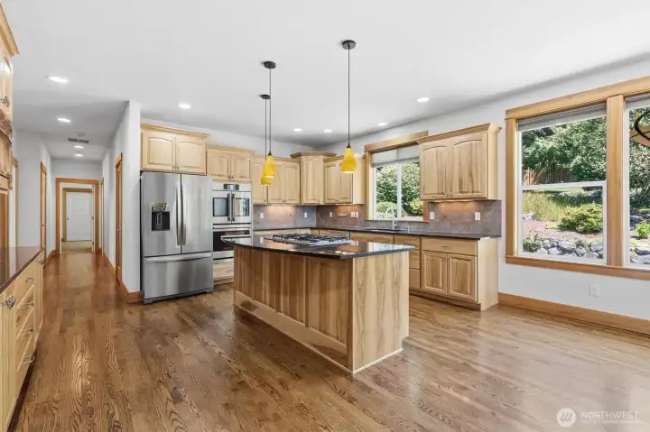 ELEGANT KITCHEN WITH QUALITY CABINETS, QUARTZ COUNTERS, & SERVING BAR.
