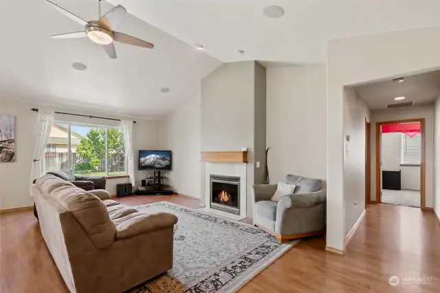 Cozy living room with a fireplace. Hallway leading towards the remainder of the house.