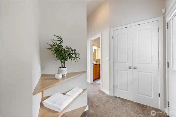 The landing at the top of the stairs has a large linen closet and built in wood shelving.