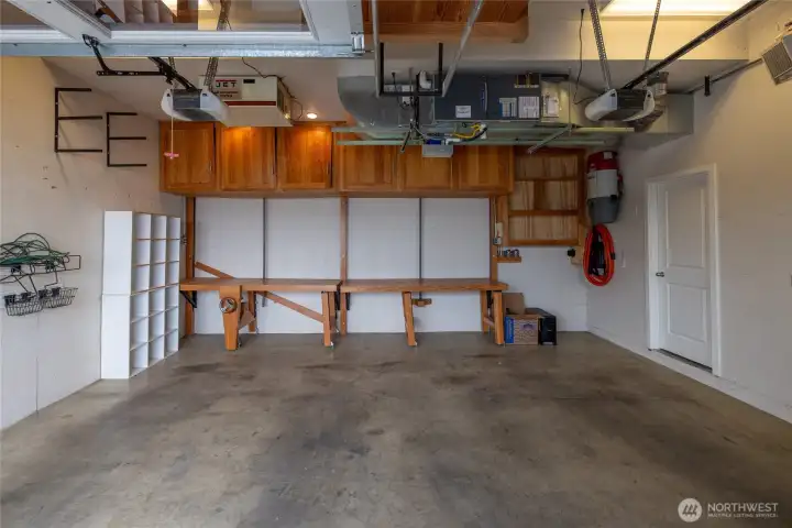 Park in comfort in the large 2 car garage with built in storage and workbenches.