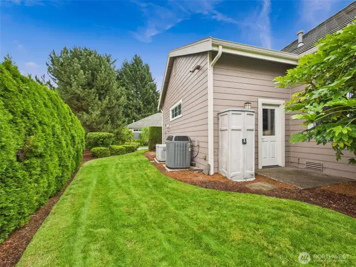 Side yard complete with tool storage, wired generator and heat pump.