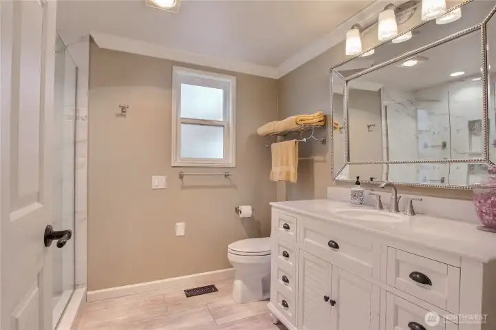 Elegant floor to ceiling tile shower with glass enclosure, newer vanity   and hardware.