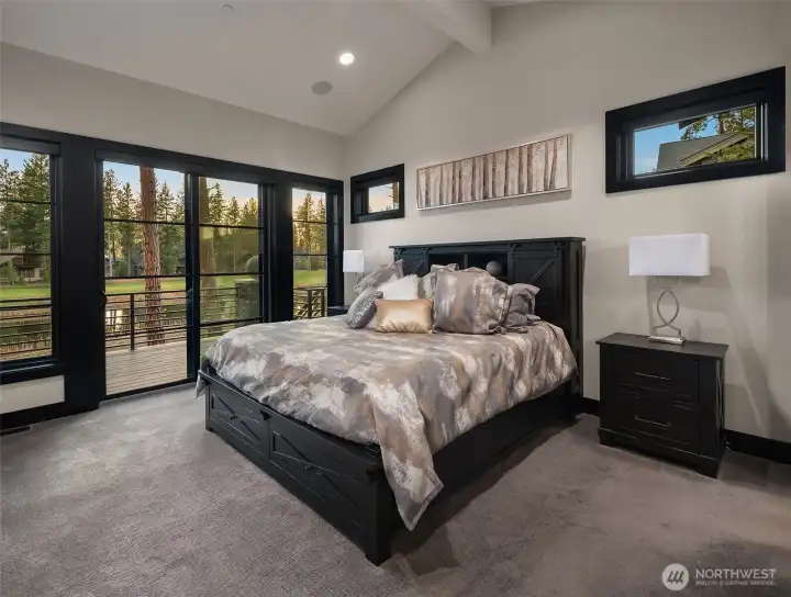 The primary suite has vaulted ceilings and large windows and a private deck