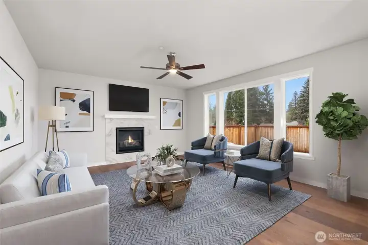 Living Room with hardwood floors, oversized and wood wrapped windows looking out to your fenced back yard.