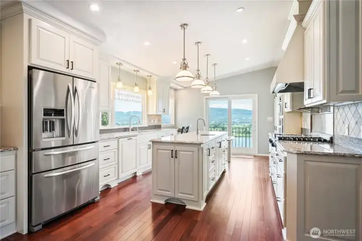 Gourmet kitchen offers abundant custom cabinetry, quartz countertops, & high end SS appliances, and more river views.