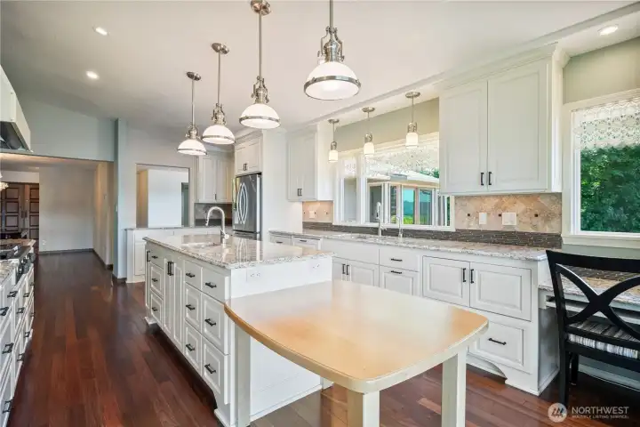 Gourmet kitchen offers abundant custom cabinetry, quartz countertops, & high end SS appliances, and more river views.