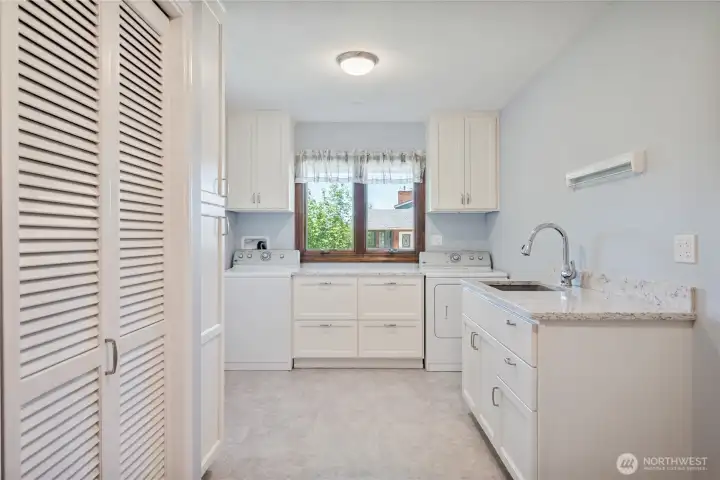 Main level laundry room with custom cabinetry and lots of storage space