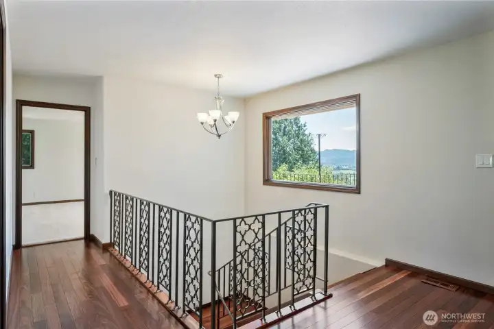 Beautiful Brazilian Teak floors and custom railing lead to the fantastic lower level with more amazing rover views!