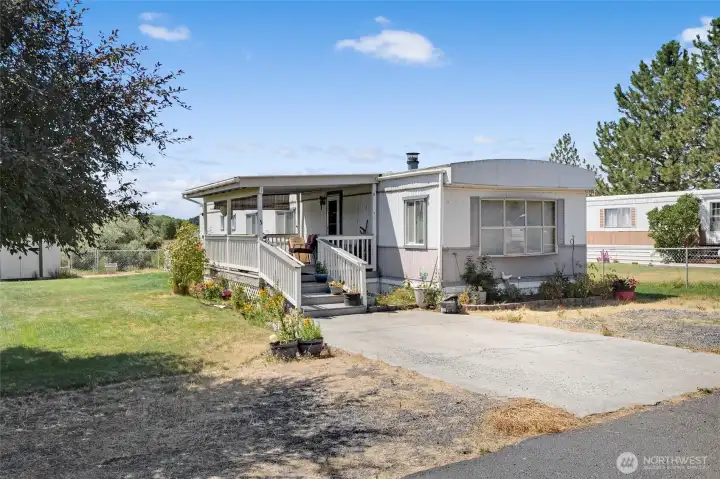 This singlewide home has the driveway and gravel parking spaces on both sides of the driveway. This singlewide home has the driveway and gravel parking spaces on both sides of the driveway.