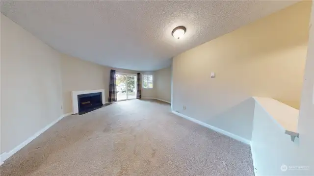 Living Room from Kitchen showing the fireplace near the sliding glass door to the patio