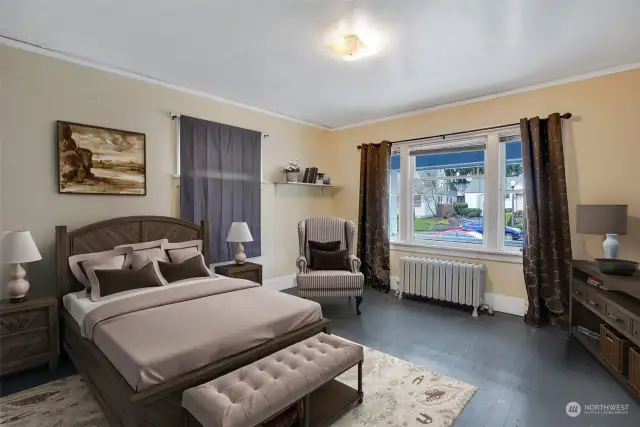 Large picture window pours natural light into this main floor bedroom. This photo has been virtually staged.