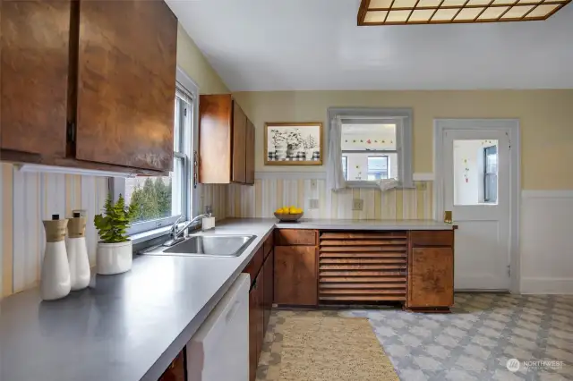 From the kitchen is an access door to laundry/mudroom. This photo has been virtually staged.