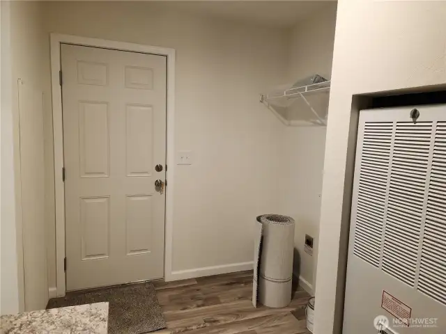 Door in utility room leads to back porch.  To the right of the door is space for a washer and dryer.  Furnace in view.