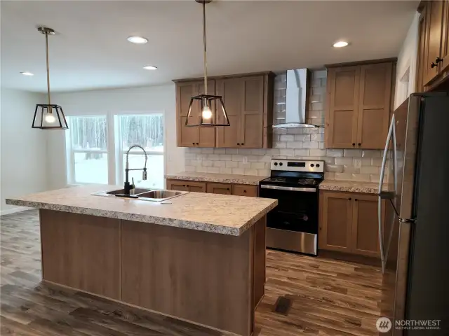 Pendant lighting above the eat-in island lights the kitchen up beautifully.