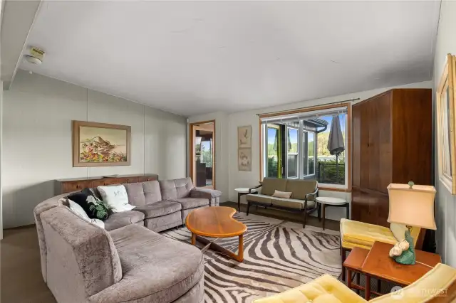 Generously sized living space leads to bonus room and deck while overlooking the water.