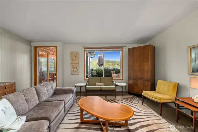 Generously sized living space leads to bonus room and deck while overlooking the water.