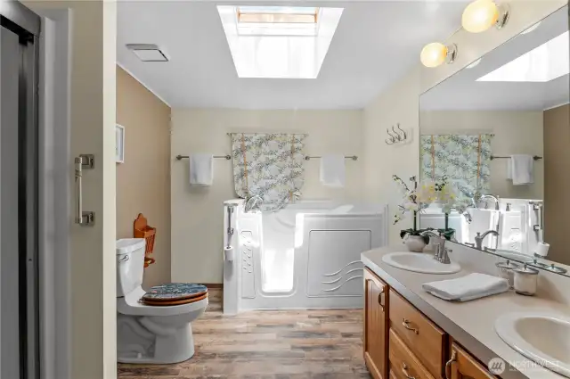 walk in tub, toilet, double vvanity and shower in this spacious primary bathroom.