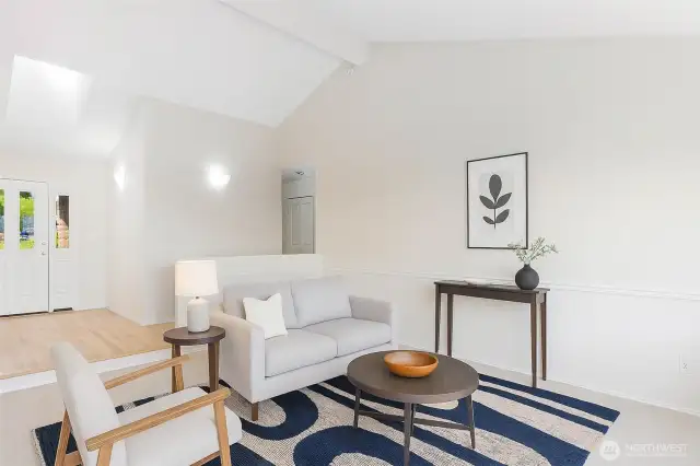 Here is the large living room staged (virial) looking back at the entry with the hallway leading to the bedrooms.  The high vaulted ceilings gives this an expansive space feel.