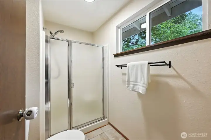 Primary bath has shower and a window to let in natural light.