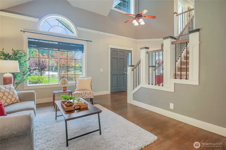A view from the dining room towards the front door. Note the arched window for interest and vaulted entry with ceiling fan. This is not your average cookie cutter home!